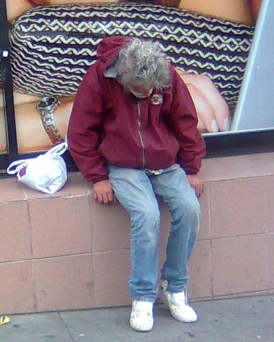 Photo of homeless man sitting on wall