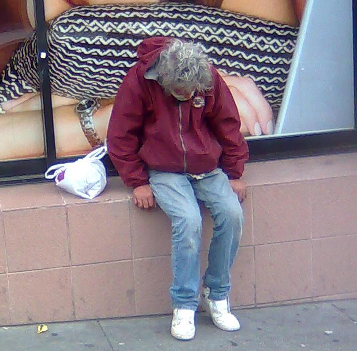 Photo of homeless man sitting on wall