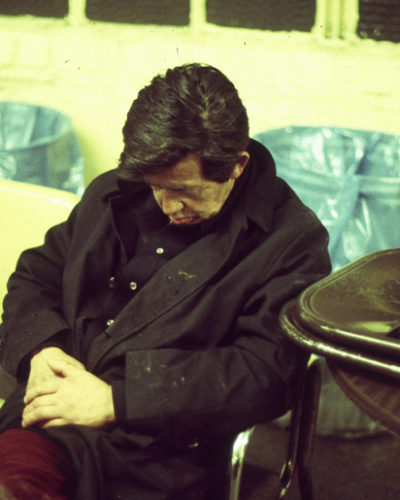 Photo of homeless man asleep on a chair